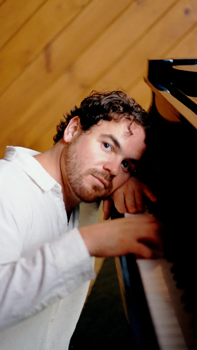 Conor Thaxter leaning on the piano